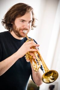 Portrait photo d'un artiste musicien qui joue de la trompette à bruxelles